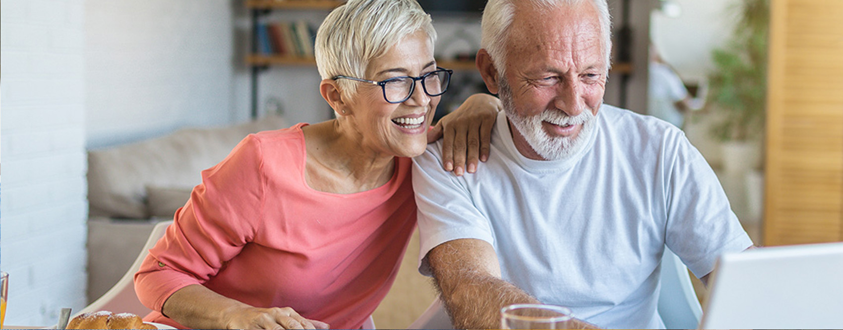 Senior couple working together at a laptop and smiling